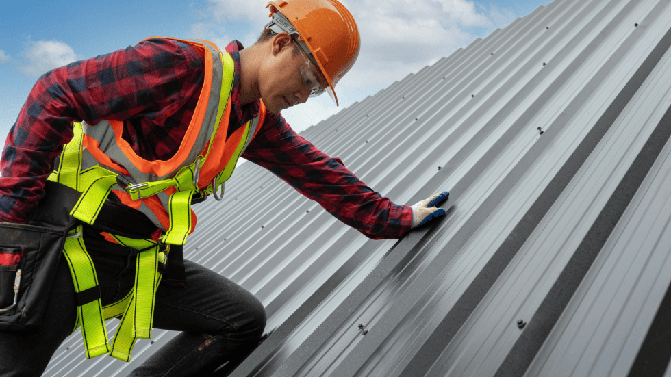 Worker with hi-vis vest stands on a very steep roof